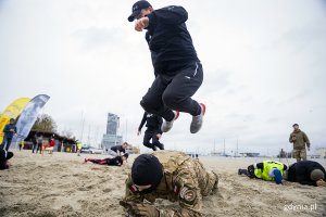 Mieszkańcy ćwiczą na plaży z komandosami.