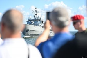 Ludzie fotografują przepływający okręt