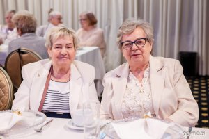 Dwie seniorki pozują do zdjęcia przy świątecznym stole 