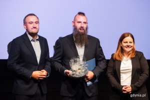 Łukasz Kołodziejski, laureat Nagrody Prezydent Miasta Gdyni dla pracowników ochrony zdrowia, wraz z prezydent Gdyni Aleksandrą Kosiorek i wiceprezydentem Tomaszem Augustyniakiem 