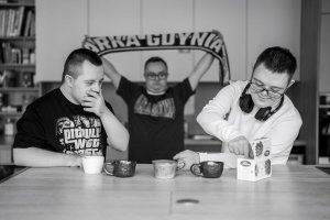 Trzech męzczyzn, jeden z szalikiem Arki Gdynia