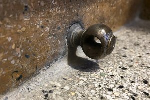 Metalowy detal na schodach klatki schodowej.