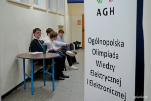 Uczestnicy olimpiady i przedstawiciele organizatora przed jedną z sal egzaminacyjnych 