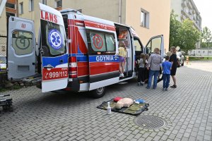 Dzieci przed karetką z otwartymi drzwiami