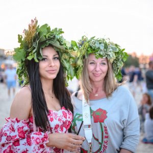 Festiwal Cudawianki. Dwie kobiety stojące na plaży w wiankach z kwiatów