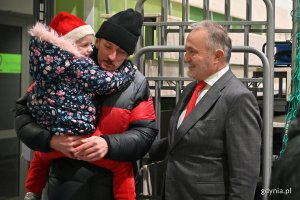 Prezydent Wojciech Szczurek wita gości wieczerzy: mężczyznę z dzieckiem