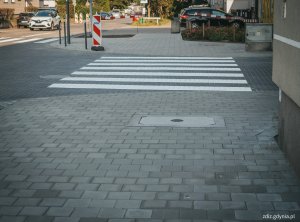 na pierwszy planie widoczny nowy chodnik z kostki, w tle przejście dla pieszych