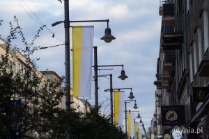 Ulica Świętojańska z ż&oacute;łto-białymi flagami watykańskimi w Dniu Papieskim