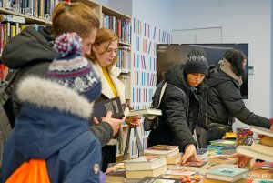Uczestnicy charytatywnego kiermaszu w Bibliotece Śr&oacute;dmieście podczas przeglądania książek 