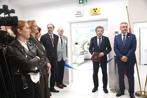 Grupa os&oacute;b przy niebieskiej wstędze