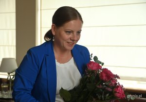 na zdjęciu kobieta z bukietem kwiatów
