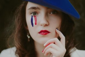 Portret kobiety, na twarzy rysunek z trzech kolorów