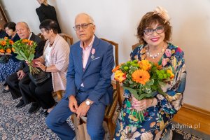 Mężczyzna w garniturze i kobieta w sukience w kwiaty