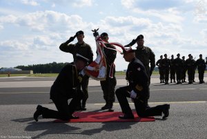 kmdr pil. Waldemar Orliński - nowy dowódca 43. Bazy Lotnictwa Morskiego (po lewej) wita się ze sztandarem bazy, całując go. sztandar trzyma poczet sztandarowy złożony z 3 żołnierzy // fot. Sebastian Smuga
