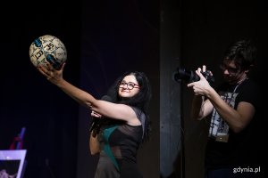 Kobieta pokazuje piłkę podczas licytacji.