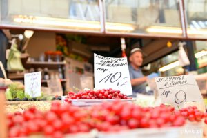 Na pierwszym planie pojemniki z czerwonymi porzeczkami i kartką z ceną z napisem: Porzeczka biała, czerwona - 10 zł opakowanie. W tle stoisko z owocami // fot. Sławomir Okoń