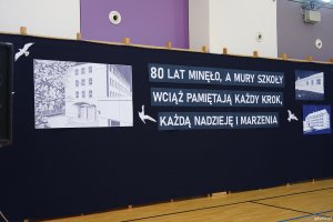 Napis na uroczystości: 80 lat minęło, a mury szkoły wciąż pamiętają każdy krok, każdą nadzieję i marzenia 