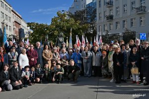 Wsp&oacute;lne zdjęcie uczestnik&oacute;w uroczystości z okazji 87. rocznicy pierwszych wysiedleń Gdynian pod Pomnikiem Gdynian Wysiedlonych