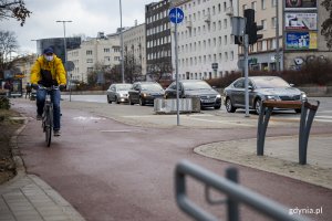 Jakub Furkal testuje nową nawierzchnię drogi rowerowej, w tle przysiadak dla pieszych / // fot. gdynia.pl