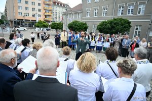 Grupa ludzi pod pomnikiem