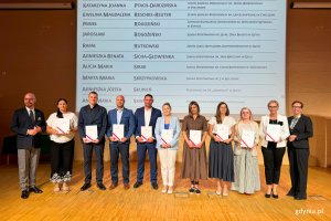 Osoby na scenie pozujące do zdjęcia po wręczeniu nominacji