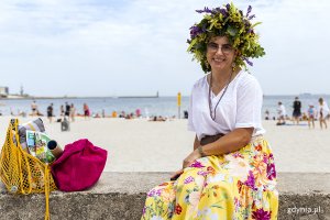 Kobieta w wianku na plaży.