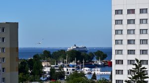 Widok spomiędzy budynków na port i morze.