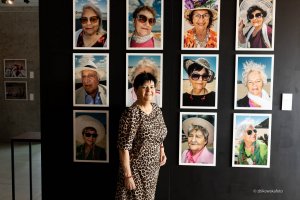 Gdyńska seniorka na tle portret&oacute;w senior&oacute;w