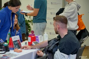 Jeden z uczestnik&oacute;w akcji z okazji Dnia Mężczyzny przy stoisku medycznym na pasażu Centrum Handlowego Riviera 