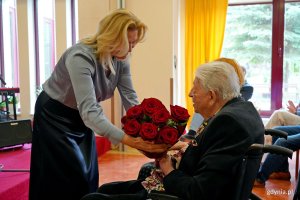 Lilianna Szewczuk-Putrym, dyrektor Domu Pomocy Społecznej w Gdyni, wręczająca kwiaty Przemysławowi Dyakowskiemu