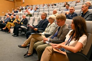 Joanna Zielińska - przewodnicząca Rady Miasta Gdyni (trzecia od prawej w pierwszym rzędzie), Tomasz Miegoń - dyrektor Muzeum Marynarki Wojennej (czwarty od prawej w pierwszym rzędzie) oraz inni uczestnicy konferencji „Wojna i morze  - od średniowiecza po współczesność” zebrani w sali audytoryjnej Muzeum Marynarki Wojennej // fot. Magdalena Czernek