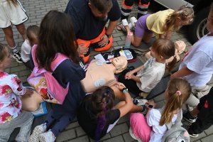 Dzieci zgromadzone wookół manekina 
