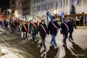 Ludzie w odświętnych strojach idący ulicą