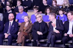 Mężczyźni i kobiety siedzący na krzesłach w auli