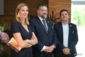 Dwaj mężczyźni i kobieta w eleganckich strojach