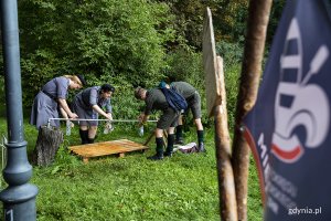 Harcerki i harcerze napełniają butelki wodą z kranu.