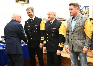 Grupa mężczyn z ż&oacute;łtymi chustami na scenie