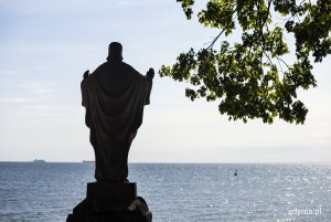 Orłowo. Na pierwszym planie sylweta figury Chrystusa i gałąź drzewa, w tle morze. Fot, Przemysław Kozłowski