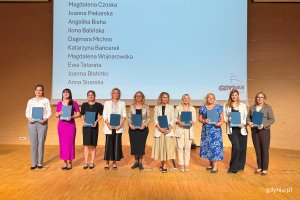 Osoby na scenie pozujace po wręczeniu nominacji