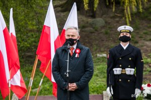Prezydent Gdyni Wojciech Szczurek wygłasza przemówienie okolicznościowe z okazji Święta Konstytucji 3 Maja. W tle biało-czerwone flagi, obok stoi marynarz w galowym mundurze // fot. Karol Stańczak