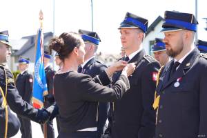 Kobieta wręcza medal mężczyźnie w mundurze