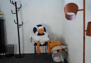 Pluszak na krzesełku w kołem ratunkowym na głowie