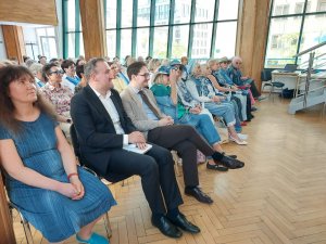 Wiceprezydent Gdyni Tomasz Augustyniak, Ricardo Jagielski &ndash; przedstawiciel Portu Gdynia oraz seniorzy i goście obecni na zakończeniu roku akademickiego 2025/2026 Gdyńskiego Uniwersytetu Trzeciego Wieku
