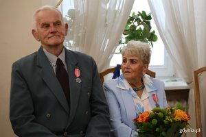 Para, mężczyzna z medalem, kobieta z bukietem kwiat&oacute;w