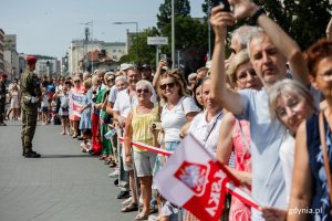Mieszkańcy miasta na pierwszym planie żołnierz w mundurze