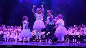 Dzieci w białych strojach na scenie