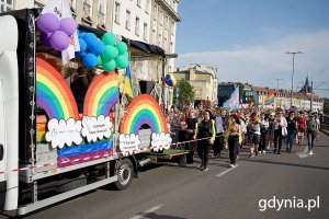Grupa osób z tęczowymi flagami i transparentami