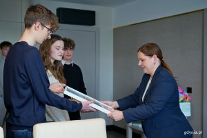 Uczniowie, kt&oacute;rzy uczestniczyli w rejsie z okazji stulecia miasta na &bdquo;Pogorii&rdquo;, przekazujący prezydent Gdyni Aleksandrze Kosiorek zdjęcie grupy z pokładu żaglowca 