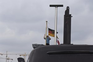 Marynarz okrętu podwodnego typu 212A „U31" wciąga na maszt niemiecką banderę, fot. Michał Kowalski