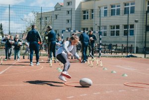 Dzieci z piłką do rugby na boisku